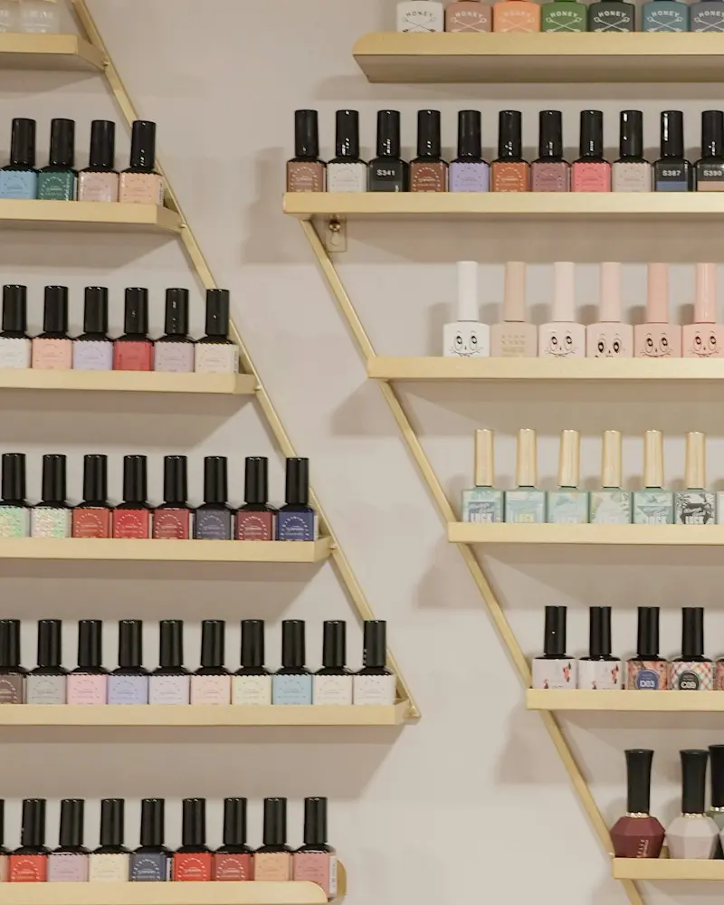 Rows of nail polish bottles in soft colours on a shelf